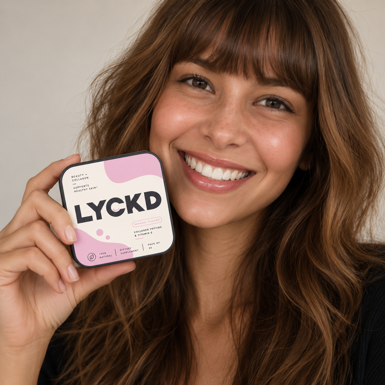 Smiling customer holding LYCKD Beauty and Collagen